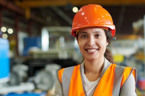 Woman in hard hat in a warehouse setting