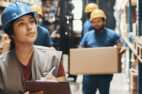 Woman with clipboard in warehouse