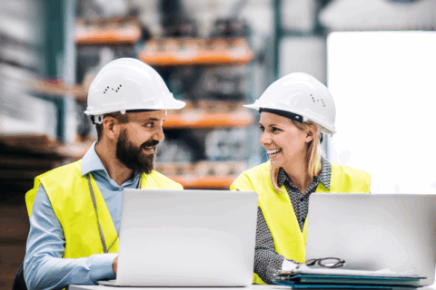 Two warehouse workers share a laugh